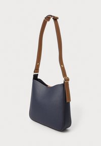 Borsa a spalla in pelle blu navy con una texture liscia, parte superiore curvata e una tracolla regolabile marrone con cuciture bianche e dettagli in metallo dorato.