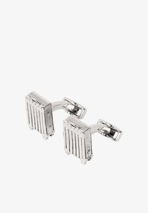 Silberne Manschettenknöpfe in Form kleiner rollender Koffer mit Griffen und Rad-Details, verbunden durch eine gebogene Stange.