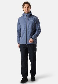 Hellblau Wasserabweisende Jacke mit hohem Kragen und Frontreißverschluss. Kombiniert mit schwarzen Hosen. Besitzt dezente Markenkennzeichnung und eine strukturierte Passform.