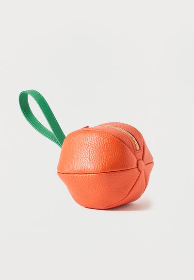 Pochette ronde en cuir texturé orange avec une fermeture à glissière dorée et une anse boucle en cuir vert, en forme de fruit d'orange.