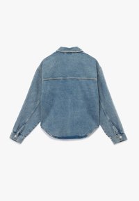 Camisa de mezclilla azul claro con mangas largas, cuello y dobladillo redondeado. Presenta detalles de costura y puños abotonados, mostrando un ajuste relajado.