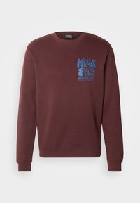 Sweat-shirt bordeaux à manches longues avec poignets et ourlet côtelés, avec texte graphique bleu « Minds Eye Scotch & Soda Amsterdam » sur la poitrine gauche.