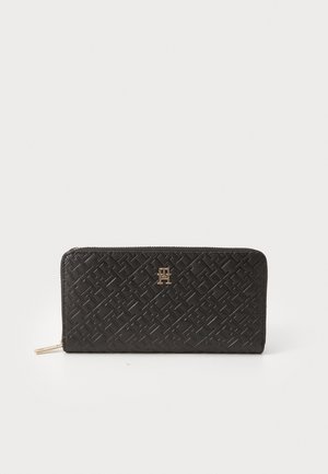 Black leather wallet with a woven texture, zip closure, and gold-tone logo accent on the front. Slim, rectangular shape.