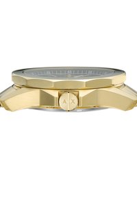 Gold-tone watch with an octagonal case, textured band, and circular dial featuring black accents and distinct hands. Engraved logo on crown.