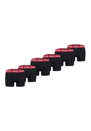 Sechs Paar schwarze Boxershorts mit roten Levi's gebrandeten Taillenbändern, diagonal auf weißem Hintergrund angeordnet.
