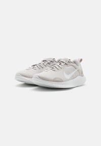 Vaaleanharmaat urheilukengät, joissa on teksturoitu kangaspäällinen, valkoinen swoosh-logo ja pehmustettu pohja. Ominaisuuksiin kuuluu lenkkikärki, joka helpottaa pukeutumista.