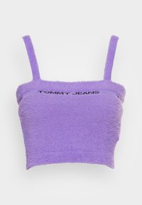 Fioletowy krótki top na ramiączkach wykonany z miękkiego, puszystego materiału. Posiada cienkie ramiączka oraz prążkowany pas z logotypem "TOMMY JEANS" w kolorze czarnym.