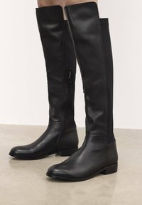 Black leather knee-high boots with a smooth texture, featuring a side zipper and square toe, finished with a low block heel.