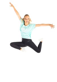 Minta vihreä oversize t-paita, jossa on "DANCE"-teksti, mustat legginsit ja valkoiset lenkkarit; dynaaminen asento, kädet ja jalat ojennettuna ilmassä.