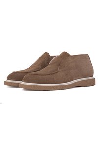 Brown suede slip-on shoes with a textured rubber sole and white trim. The design features a rounded toe and minimal stitching accents.