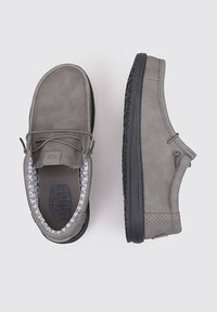 Grijze leren schoenen met een ronde neus, stikwerk details en een zwarte rubberen zool. Het interieur heeft een patroon voering. Twee gestructureerde veterogen.