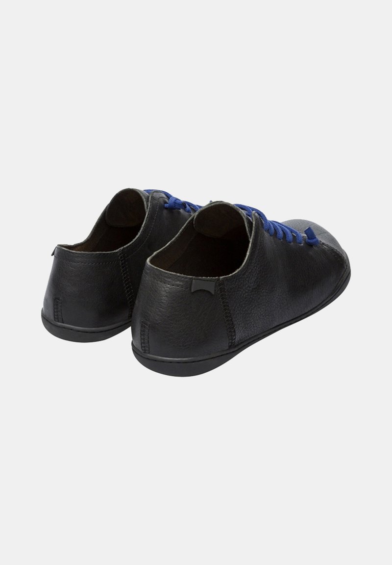 Chaussures en cuir noir avec des lacets bleus, design rond, silhouette basse et style minimaliste. Surface texturée sans accents visibles.