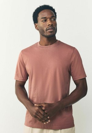 Kurzärmliges T-Shirt mit Rundhalsausschnitt in Staubrosa, aus weichem Stoff mit glatter Textur, mit lässiger Passform und schlichtem Design.