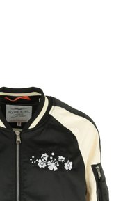Czarna kurtka lotnicza z kremowymi rękawami, z kwiatowym haftem z przodu, prążkowanym kołnierzem oraz zamykanymi na zamek kieszeniami po bokach.
