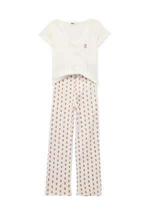 Witte top met korte mouwen en knopen met een klein teddybeertje patch, gecombineerd met bijpassende wijde broek met teddybeerprint.