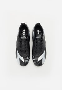 Black athletic shoes with silver accents, featuring a sleek design, textured surface, and traditional lacing. Notable striped pattern on sides.