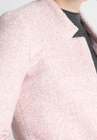 Helle pinke Wollmischjacke mit strukturierter Oberfläche, Reverskragen und Ein-Knopf-Verschluss, mit tailliertem Schnitt und klaren Linien.