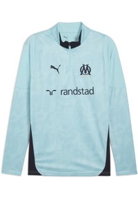 T-shirt de sport à manches longues bleu clair avec col zippé, présentant un motif texturé subtil, des accents noirs et les logos de Puma et Randstad.