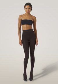 Sort strapless top parret med højtaljede, t�ætsiddende mørkebrune leggings; glat tekstur, subtil glans og strømlinet design.