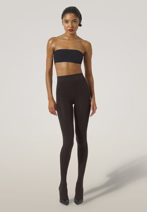 Top sans bretelles noir associé à un legging marron foncé taille haute et ajusté ; texture lisse, léger brillantage et design épuré.