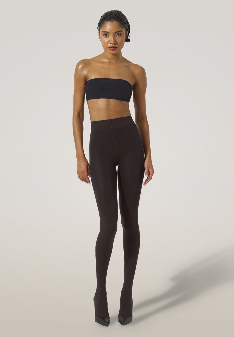 Sort strapless top parret med højtaljede, tætsiddende mørkebrune leggings; glat tekstur, subtil glans og strømlinet design.