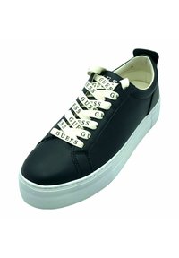 Sneaker in pelle nera con suola in gomma bianca. Presenta lacci crema stampati con "GUESS." Design low-profile, punta rotonda e linguetta sul retro.