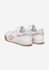 Sneaker bianche con accenti rosa, tomaia in pelle, suola in gomma, dettaglio del logo sul retro e leggera imbottitura sul collo. Stile: CAMPIO XT.