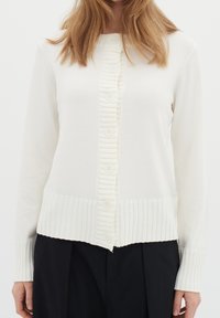 Bílý pletený cardigan s texturovaným légou se pěti knoflíky, žebrovaným lemem a detaily manžet a jemnou, hladkou texturou látky.