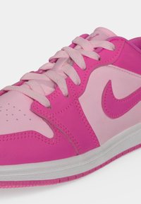 Розов и светлорозов Nike маратонка с бяла подметка, видими връзки и лого на Nike swoosh отстрани.