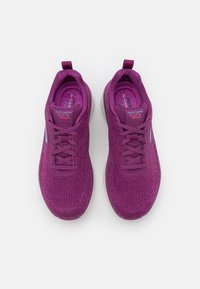 Lila stickade sportskor med texturerad yta, snörningsdesign och kontrasterande blå detaljer. Mjuk sula för komfort.