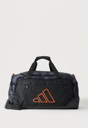 Μαύρη και σκούρα γκρι αθλητική τσάντα duffel με πορτοκαλί λογότυπο Adidas, διπλές λαβές, εμπρόσθια τσέπη με φερμουάρ και ρυθμιζόμενο ιμάντα ώμου.