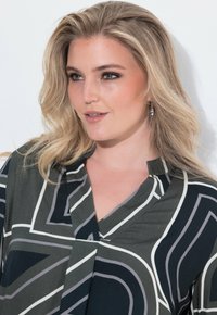 Grøn blouse med mønster i hvid og grå linjer, kravesnit, blødt stof og afslappet pasform. Modellen har en subtil makeup på.