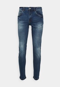 Jeans de mezclilla oscuro con un diseño ajustado, un ligero desgaste, cinco bolsillos y un cierre de botón en la cintura. Textura suave en toda su extensión.