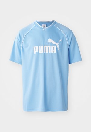 Himmelblå sportstrøje lavet af åndbart stof, med et hvidt "PUMA" logo og en kontrastfarvet V-halsudskæring samt raglan ærmer.