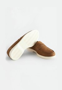 Brązowe skórzane loafersy o gładkiej fakturze, z przeszywanym wzorem i białą gumową podeszwą z falistym wzorem.