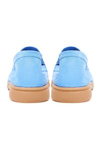 Paire de mocassins en daim bleu clair avec semelles en caoutchouc couleur camel, vues de dos sur fond blanc.