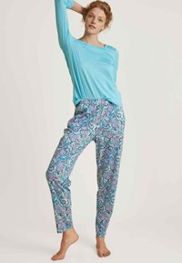 Lichtblauw langemouwtop met een relaxte pasvorm; geprinte joggerbroek in blauw, roze en groene draaikolken; zachte stof, elastische tailleband.