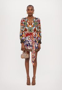 Colorful floral-patterned mini dress with long sleeves, v-neck, cinched waist, and a matching belt. Features a detailed border and beaded accents.