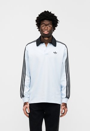 Lichtblauw poloshirt met lange mouwen, een zwarte kraag en drie zwarte strepen op elke mouw; heeft een geborduurd logo op de borst.