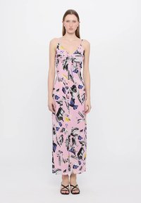 Rožinė maksi suknelė su raštuotu dizainu, kuriame yra abstrakčios formos juodos, mėlynos ir geltonos spalvų. Lengvas audinys su reguliuojamomis spaghetti petnešėlėmis.