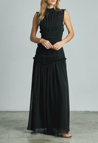 Schwarzes Maxikleid mit ärmellosem Design, gefälteltem Oberteil und schwingendem Rock. Mit gerafften Akzenten an der Taille und dem Saum.