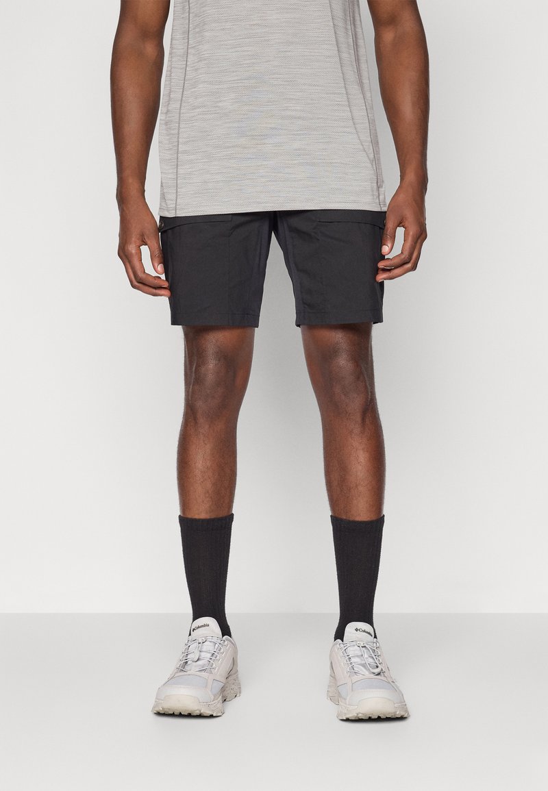 Sorte shorts med to sidelommer, kombinert med en lys grå stripete skjorte, sorte sokker og lysegrå sneakers.