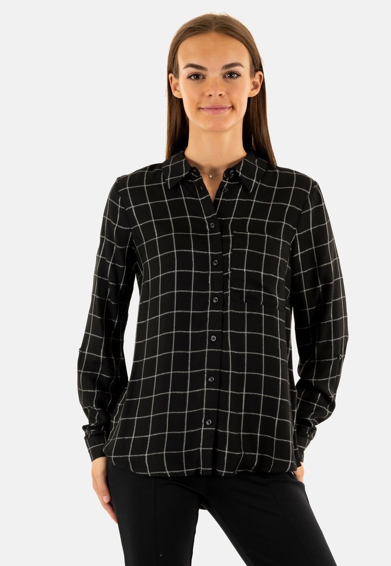 Camisa negra de botones con patrón de cuadrícula blanca, mangas largas, bolsillo en el pecho y textura suave, con un corte recto y cuello.