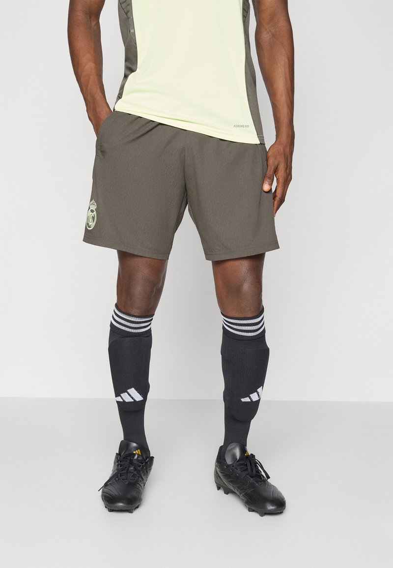 Mørkegrå atletikshorts med logo, parret med sorte knæhøje sokker med hvide striber. Sorte fodboldstøvler med snørebånd.