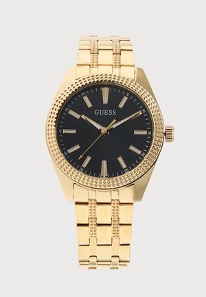 Montre Guess couleur or, avec un cadran noir, des index et des aiguilles dorés, ainsi qu’un bracelet en métal texturé.