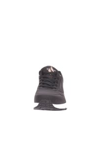 Schwarzer Sportschuh mit strukturierter Oberfläche, Schnürdesign und weißer Sohle. Verfügt über ein Logo auf der Zunge und ein Gummilaufsohlenmuster.