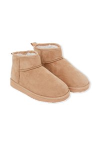 Stivaletti alla caviglia in suede tan con morbido rivestimento bianco, suole in gomma piane e un pratico cinturino sul retro per una facile calzata. Texture liscia in tutto.
