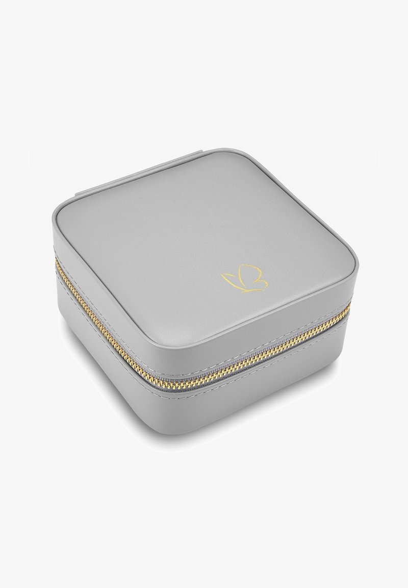 Harmaa nahkainen korurasia neliön muotoinen, kultavetoketjulla ja kohokuvioidulla perhoslogolla kannessa. Suora pinta ja minimalistinen muotoilu.