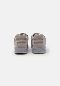 Grey suede and mesh sneakers with a textured finish, featuring padded tongues, a cushioned sole, and "Saucony" branding on the heel.