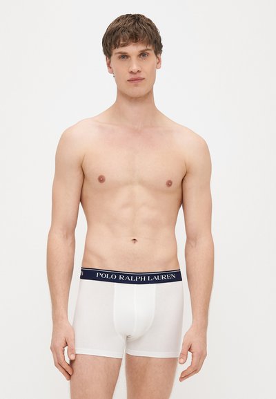 Białe bokserki z granatowym elastycznym paskiem w talii z napisem "POLO RALPH LAUREN". Tkanina jest gładka i dobrze dopasowana.